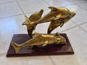 Photo of Brass Dolphins Playing in the Ocean